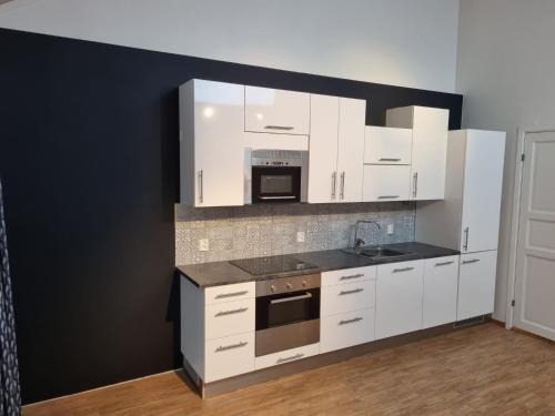 a kitchen with white cabinets and a stove top oven at Appartment Morana, Falkum in Skien