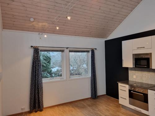 una cocina con armarios blancos y una ventana en Appartment Morana, Falkum, en Skien