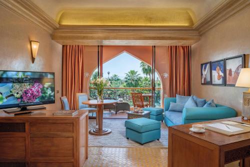 un salon avec un canapé bleu et une télévision dans l'établissement Es Saadi Marrakech Resort - Palace, à Marrakech