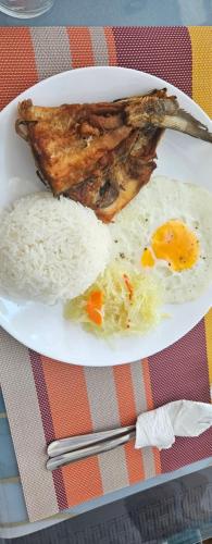 a plate of food with rice and an egg at Dapdap ShoreLINES Beach House in San Francisco