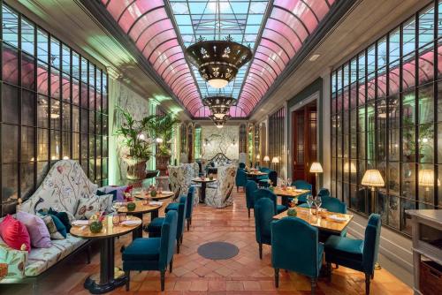 佛羅倫斯的住宿－佛羅倫薩海爾維迪亞&布里斯托爾酒店- 星際酒店集團，餐厅设有桌椅和窗户。
