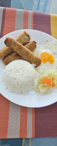 a plate of food with rice and eggs and sausage at Dapdap ShoreLINES Beach House in San Francisco