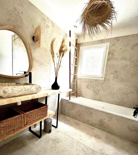 une salle de bain avec une baignoire, un lavabo et un miroir dans l'établissement Villa Rose, à Solliès-Toucas