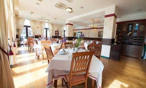 a dining room with tables and chairs in a restaurant at Hotel Ana in Arad