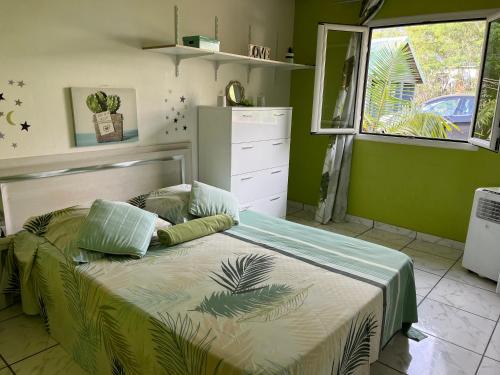 een slaapkamer met een bed met groene muren bij La Villa Soleil in Trois Bassins