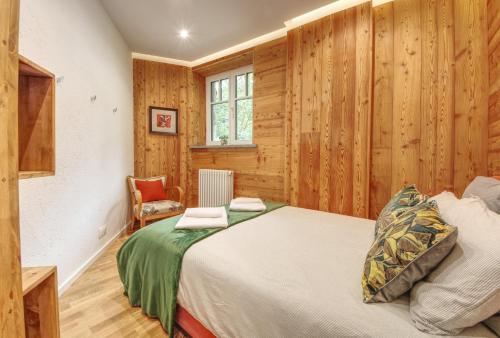 - une chambre avec un lit et des murs en bois dans l'établissement Apartment Bonatti 202, à Chamonix-Mont-Blanc
