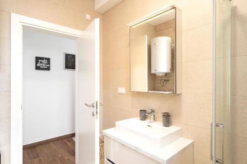 een badkamer met een wastafel en een spiegel bij Seafront Apartment Totally Beachin with Private Pool in Ivan Dolac
