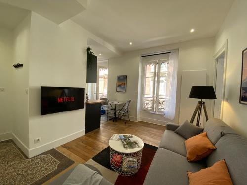 un salon avec un canapé et une télévision dans l'établissement La Suite Championnet, à Grenoble