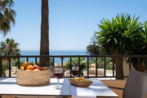 een tafel met een fruitmand en twee glazen wijn bij Mijas Costa Blue Sky Sea Views by ALFRESCO STAYS in Mijas Costa