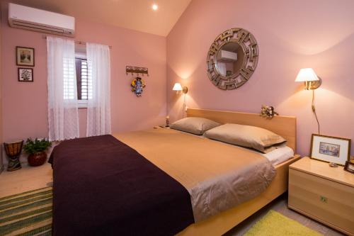 a bedroom with a large bed and a mirror at Villa Jasmine in Dol