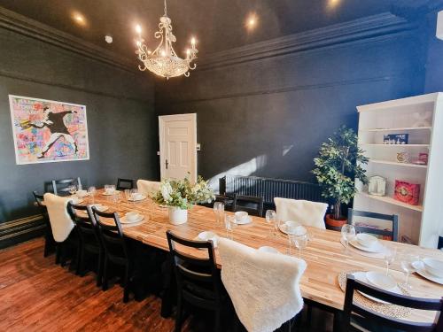 a large table in a room with chairs and a chandelier at 6 Bed Mansion Sleeps 20 Free Parking in Ashton under Lyne
