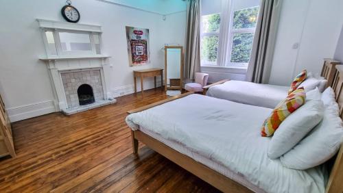 a living room with a bed and a fireplace at Sleeps 20 Stunning Ashton Mansion in Ashton under Lyne