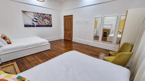 a white room with a bed and a chair at Ashton Mansion, Sleeps 20, Free Parking in Ashton under Lyne