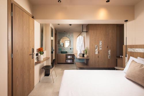 een slaapkamer met een groot bed en een badkamer bij Cosmeen Lifestyle Boutique Stay in Chersonissos