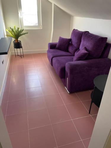 a purple couch in a living room with a tile floor at Apartamento en Covas in Ferrol