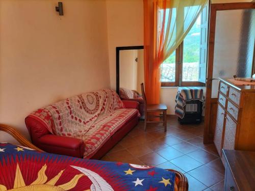 een woonkamer met een bank en een raam bij Casa Vacanze Relax Etna in San Giovanni la Punta