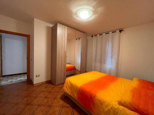 - une chambre avec un lit et une couverture colorée dans l'établissement Residenza Rovetta, à Rovetta
