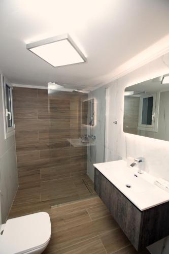a bathroom with a sink and a toilet and a mirror at Libra Apartment in Nafplio in Nafplio