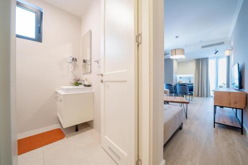 ein weißes Badezimmer mit einem Waschbecken und einem Tisch in der Unterkunft Invictus Hotel in Budva