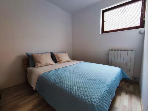 PobegiにあるOlea Mar apartmaのベッドルーム1室(青い掛け布団、窓付)