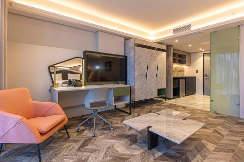 a living room with a desk and a tv and a chair at Coastlands Skye Hotel, Ridgeside, Umhlanga in Durban