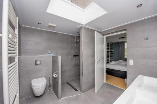 uma casa de banho com um chuveiro, um WC e uma cama em Holidayhouse Bongel 1 Ter Herne em Terherne