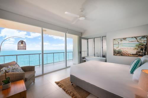 a bedroom with a large bed and a view of the ocean at Grand Mercure Apartments Magnetic Island in Nelly Bay