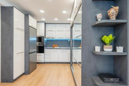 a kitchen with white cabinets and a stainless steel refrigerator at Zenith Apartment in Sofia