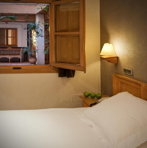 a bedroom with a bed and a cabinet and a window at Pintor El Greco in Toledo