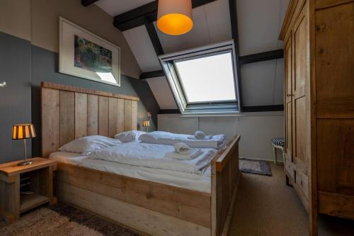 Un dormitorio con una cama grande y una ventana en Appartement - Duinweg 117-14 Zoutelande, en Zoutelande
