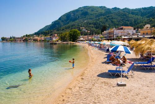 a beach with a group of people in the water at Potamaki Beach Hotel in Benitses