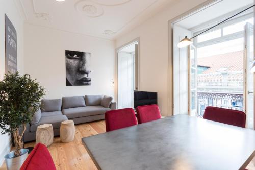 MY LX FLAT Baixa Alfama Apartments في لشبونة: غرفة معيشة مع طاولة وكراسي حمراء
