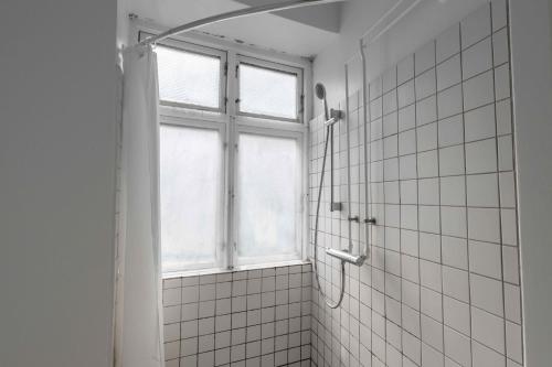 baño con ducha y ventana en Lovely Flat in Vibrant Area, en Copenhague