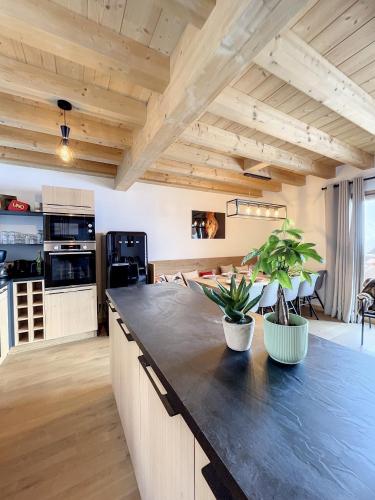 une cuisine avec un grand comptoir noir dans l'établissement Chalet Le Méan-Martin, à La Toussuire