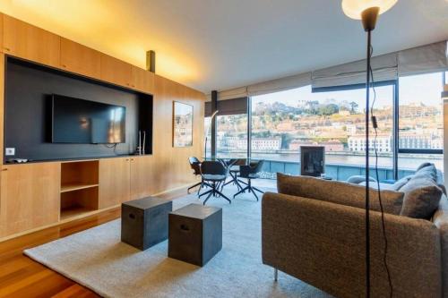 a living room with a couch and a flat screen tv at MY DOURO VIEW Luxury Apartment River Front in Vila Nova de Gaia