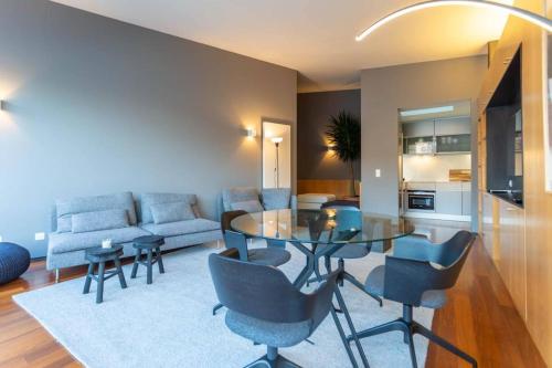 a living room with a glass table and blue chairs at MY DOURO VIEW Luxury Apartment River Front in Vila Nova de Gaia