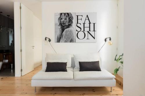 eine weiße Couch in einem Wohnzimmer mit einem Bild an der Wand in der Unterkunft MY LX FLAT Bairro Alto Design Apartments in Lissabon