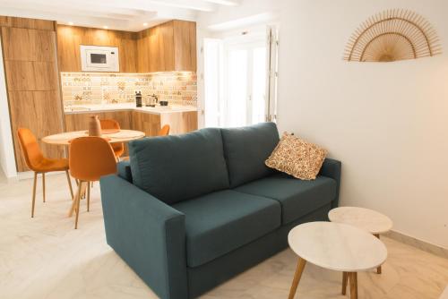 salon z niebieską kanapą i stołem w obiekcie Torre Solana 41 w Kadyksie