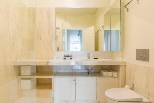 W łazience znajduje się umywalka, toaleta i lustro. w obiekcie MY LX FLAT Luxury Chiado Design Apartment w Lizbonie