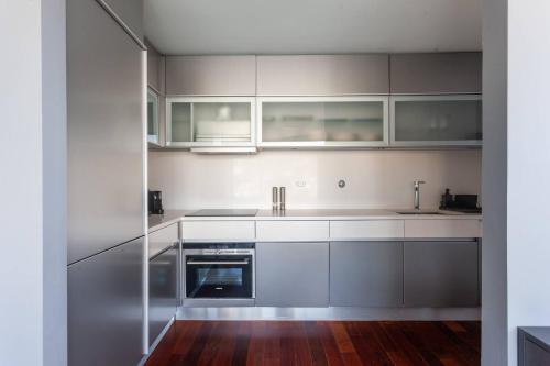 a kitchen with white cabinets and stainless steel appliances at MY DOURO VIEW Stylish Gem River Front in Vila Nova de Gaia