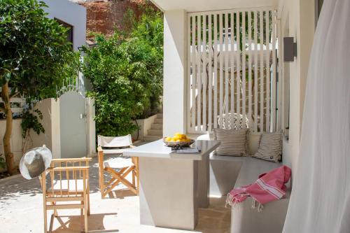 a patio with a white table and a chair at Kynthia Suite - Escape to Seaside Makry Gialos in Makry Gialos