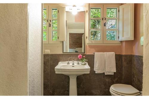 La salle de bains est pourvue d'un lavabo, de toilettes et d'un miroir. dans l'établissement Villa Linchiano, à Gambassi Terme