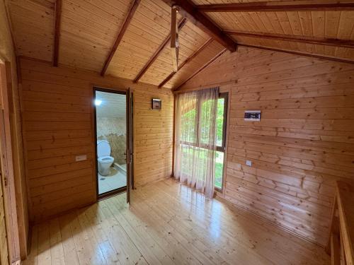 Harsnadzor Eco Resort في Halidzor: غرفة فارغة مع مرحاض في منزل خشبي