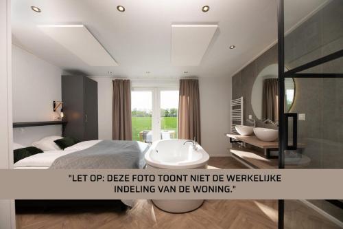 a bedroom with a bath tub and a bathroom at Panorama Wellness Lodge jacuzzi sauna and sunshower 2 persons in Rijssen