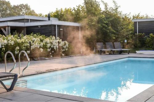 a swimming pool in a yard with a house at Panorama Wellness Lodge jacuzzi sauna and sunshower 2 persons in Rijssen