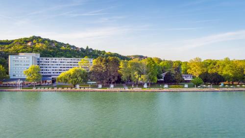 a large body of water in front of a building at Hotel Club Tihany in Tihany