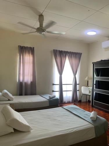 um quarto com 2 camas e uma ventoinha de tecto em Landed 3BR near Bangi Wonderland - Wi-Fi, Netflix em Kajang