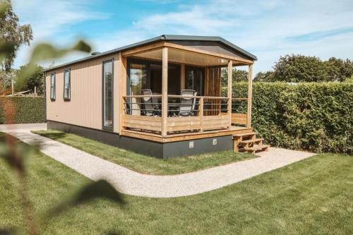 a tiny house on the grass in a garden at 4-persoons Tiny Lodge in Voorthuizen