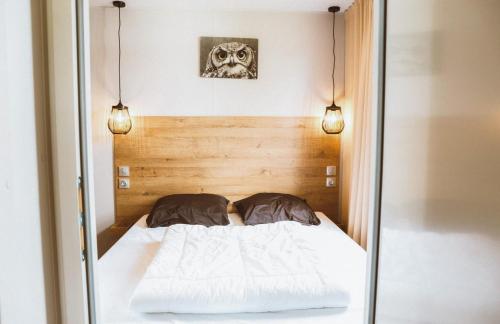 a bed in a room with two lights at 4-persoons Tiny Lodge in Voorthuizen