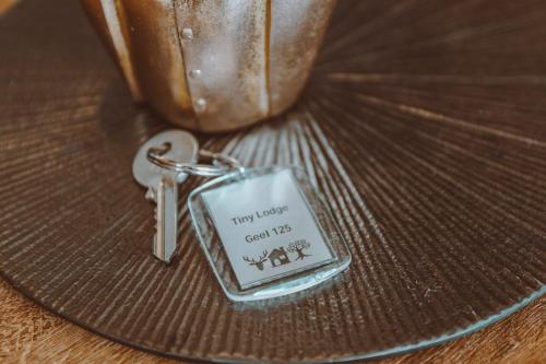 a keychain with a tag that says twentyseven eachtis xxx at 4-persoons Tiny Lodge in Voorthuizen